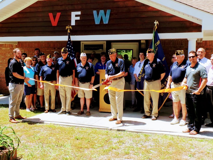 Commander, Rick Arvonio, cuts the ribbon during the Brunswick County Chamber of Commerce ribbon cutting ceremony on May 1st, 2018.